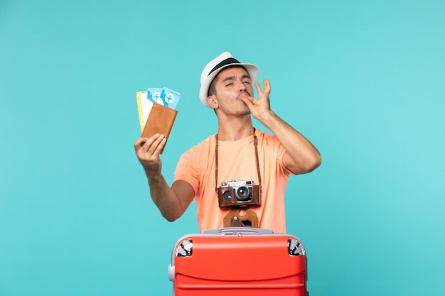 Bezpłatne zdjęcie widok z przodu mężczyzna na wakacjach trzymający swoje bilety na jasnoniebieskim kolorze