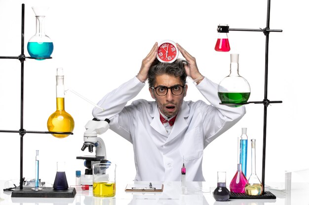 Widok z przodu mężczyzna naukowiec w garniturze trzymając zegary na białym tle chemia covid lab virus health
