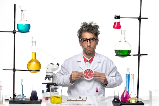 Widok z przodu mężczyzna naukowiec w garniturze trzymając zegary na białym tle chemia zdrowie wirus laboratoryjny covid