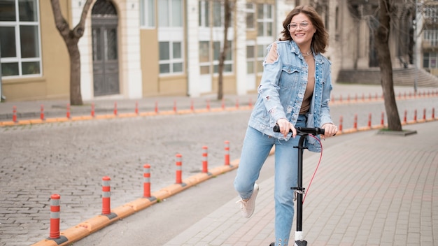 Bezpłatne zdjęcie widok z przodu młoda kobieta jedzie skuterem elektrycznym