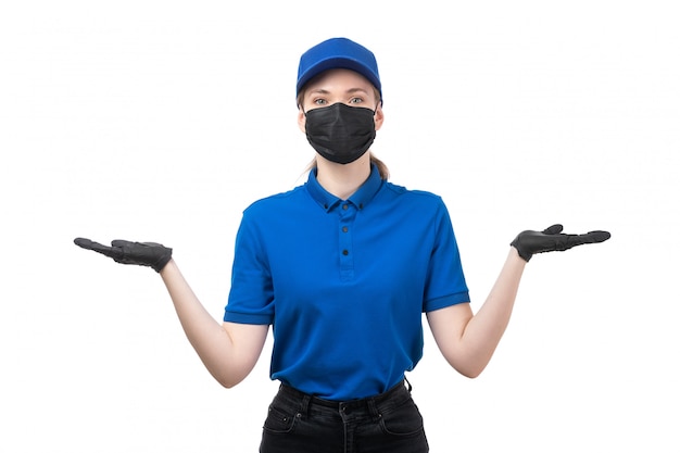 Widok z przodu młoda kobieta kurier w niebieskie jednolite czarne rękawiczki i czarna maska pozowanie