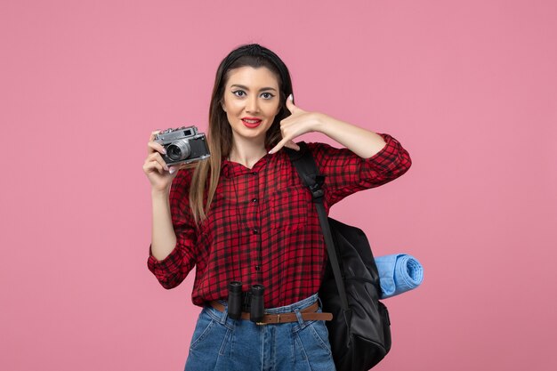 Widok z przodu młoda kobieta robienie zdjęć aparatem na różowym tle kolor zdjęcia kobiety