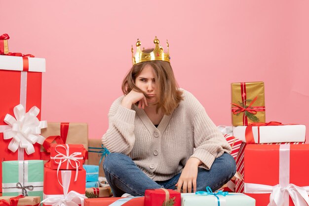 Widok z przodu młoda kobieta siedzi wokół świątecznych prezentów