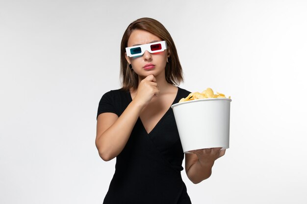 Widok z przodu młoda kobieta trzyma chipsy d okulary przeciwsłoneczne na białej powierzchni