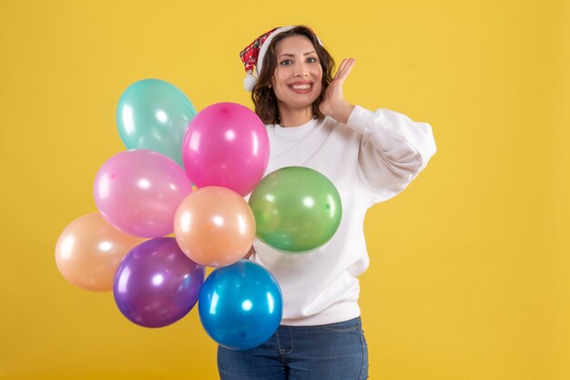 Widok z przodu młoda kobieta trzyma kolorowe balony na żółto