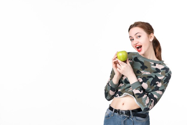 Widok z przodu młoda kobieta trzymająca zielone jabłko białe tło sok ze skóry poziome zdrowie ludzkie zdrowie owoce