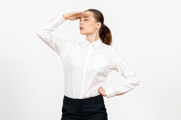 Widok z przodu młoda kobieta w białej bluzce patrząc na odległość na białym tle praca w biurze kobiece emocje model uczucia