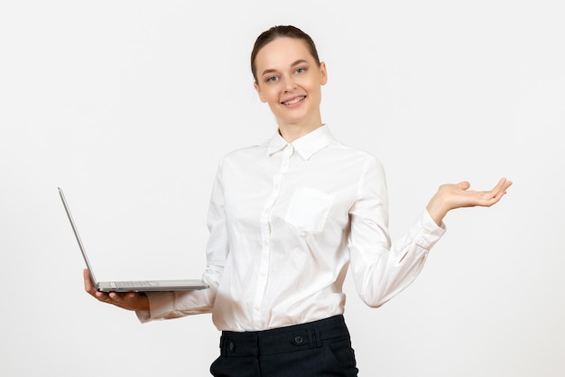 Widok z przodu młoda kobieta w białej bluzce za pomocą laptopa i uśmiechnięta na białym tle biuro pracy kobiece uczucie model emocji