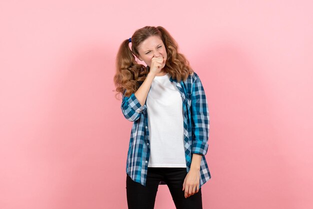 Widok z przodu młoda kobieta w niebieskiej kraciastej koszuli na różowej ścianie młodzieżowe emocje dziewczyna dziecko modelka moda