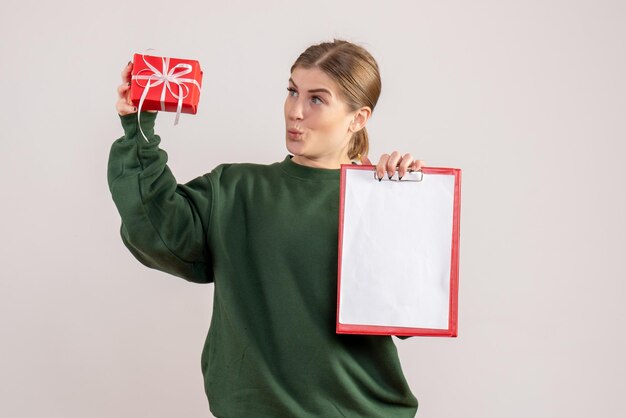 Widok z przodu młoda kobieta z małym świątecznym prezentem i notatką