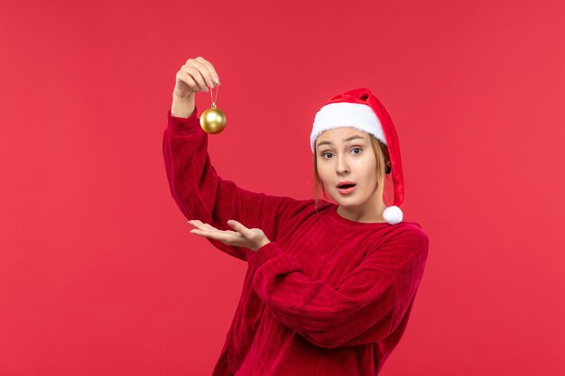 Widok z przodu młoda kobieta z świąteczną zabawką, święta bożego narodzenia czerwony