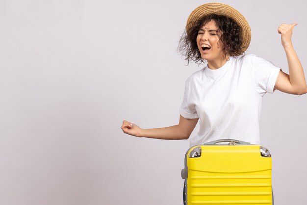 Widok z przodu młoda kobieta z żółtą torbą przygotowuje się do podróży ciesząc się na białym tle wakacje podróż kolor lot samolot turystyczny odpoczynek