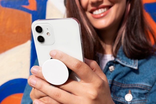 Bezpłatne zdjęcie widok z przodu młoda kobieta za pomocą popsocket