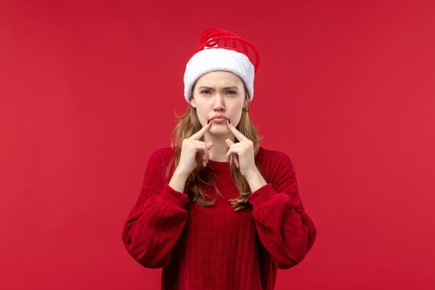 Bezpłatne zdjęcie widok z przodu młoda kobieta ze smutnym wyrazem twarzy, czerwone święta bożego narodzenia