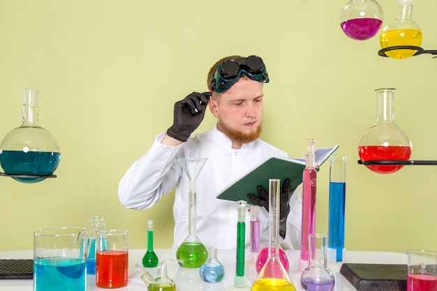 Widok z przodu młodego chemika czytającego niezbędne informacje o chemikaliach