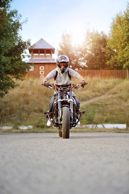 Widok z przodu młodego silnego rowerzysty jadącego na motocyklu sportowym