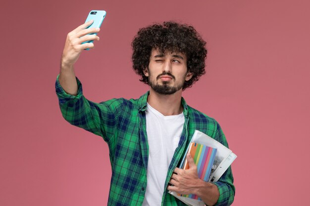 Widok z przodu młody człowiek przy selfie, mrugając