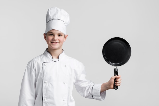 Bezpłatne zdjęcie widok z przodu młody kucharz trzyma patelnię
