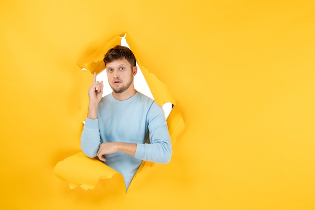 Widok z przodu młody mężczyzna na żółtej rozdartej ścianie
