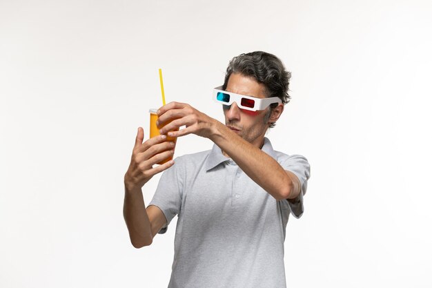 Widok z przodu młody mężczyzna trzyma sodę i nosi okulary przeciwsłoneczne d na białej ścianie człowiek film samotny pilot