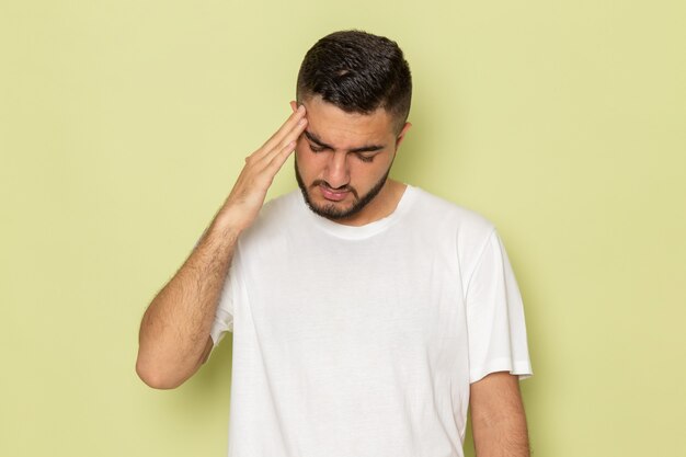 Widok z przodu młody mężczyzna w białej koszulce o bólu głowy