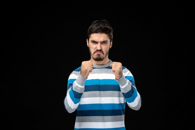 Bezpłatne zdjęcie widok z przodu młody mężczyzna w niebieskiej koszulce w paski z gniewnym wyrazem twarzy