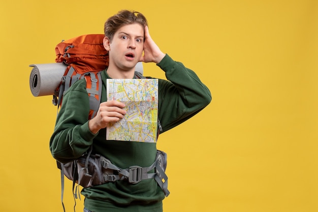 Bezpłatne zdjęcie widok z przodu młody mężczyzna z plecakiem trzymającym mapę