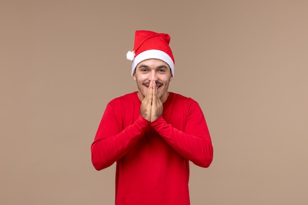 Widok z przodu młody mężczyzna z zachwyconym wyrazem na brązowym tle święta Bożego Narodzenia emocji