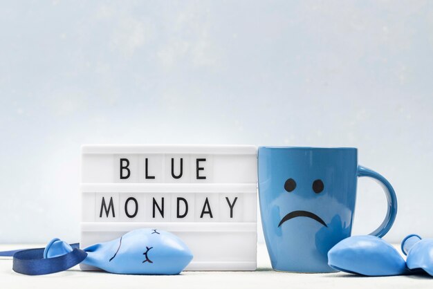 Widok z przodu na kubek z marszczeniem brwi i podświetlanym pudełkiem na niebieski poniedziałek