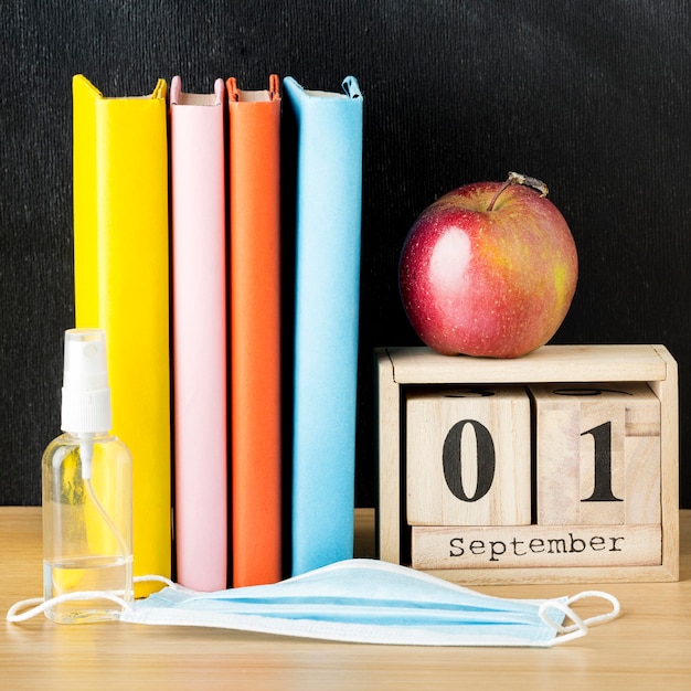 Widok z przodu na niezbędne akcesoria do szkoły z książkami i jabłkiem