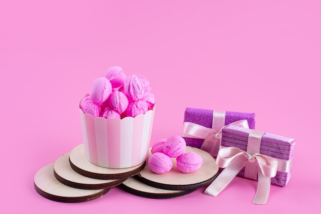 Widok z przodu na różowo, ciasteczka pyszne i pyszne oraz fioletowe pudełka na prezenty na różowym, cukierkowym cukierku herbatnikowym