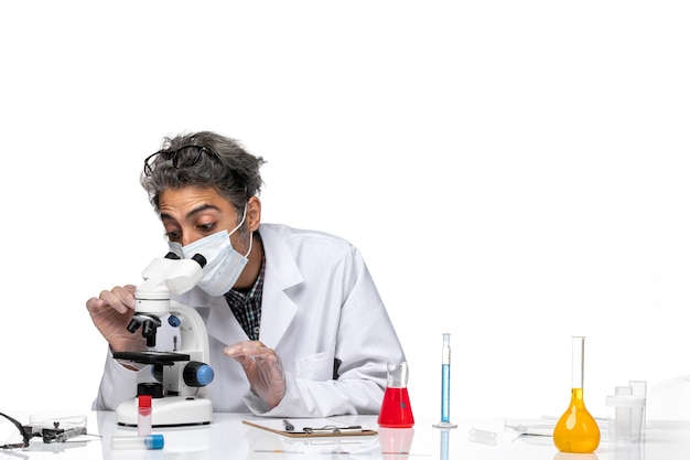 Widok Z Przodu Naukowiec W średnim Wieku W Białym Garniturze Medycznym, Próbujący Użyć Mikroskopu