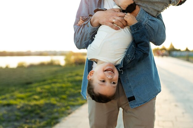 Widok z przodu ojca trzymającego dziecko do góry nogami