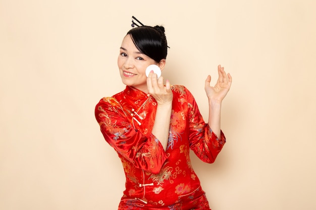 Widok Z Przodu Piękna Japońska Gejsza W Tradycyjnej Czerwonej Japońskiej Sukni Z Włosami Wystającymi Z Małej Białej Bawełny Czyszczącej Twarz Na Ceremonii Kremowej W Japonii