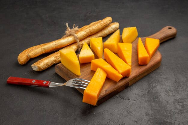 Widok z przodu pokrojony w plasterki świeży ser z bułeczkami na ciemnym zdjęciu przekąska kolorowa przekąska chipsy śniadaniowe