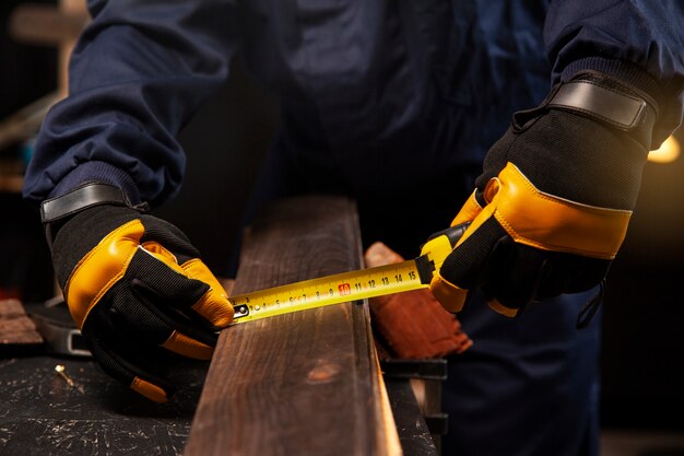 Widok z przodu pracownik mierzący kawałek drewna