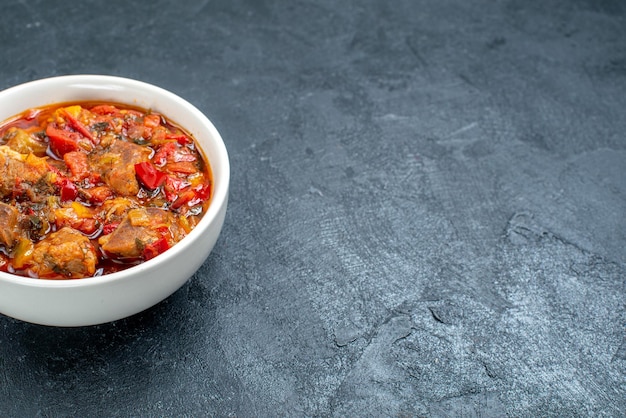 Widok z przodu pyszna zupa jarzynowa z mięsem wewnątrz talerza na szarej przestrzeni