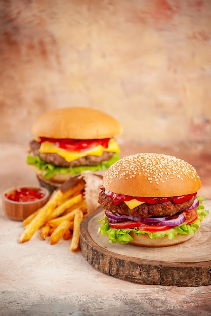 Widok z przodu pyszne cheeseburgery z frytkami na desce do krojenia jasne tło sałatka fast food ziemniaczana kanapka danie obiad burger przekąska