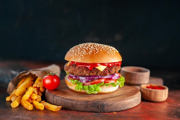 Widok z przodu pyszny cheeseburger mięsny z frytkami na ciemnym tle kolacja hamburgery przekąska fast-food kanapka sałatka danie tosty