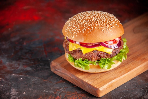 Widok z przodu pyszny cheeseburger z mięsnymi pomidorami i zieloną sałatą na ciemnym tle kanapka fast-food posiłek danie frytki kolacja