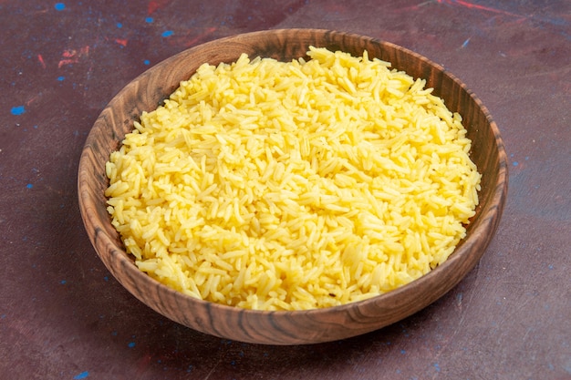 Bezpłatne zdjęcie widok z przodu pyszny gotowany ryż wewnątrz brązowego talerza w ciemnej przestrzeni