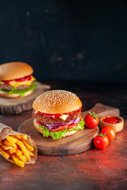 Widok z przodu pyszny mięsny cheeseburger z frytkami na ciemnym tle obiad przekąska fast-food kanapka sałatka danie tosty