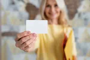 Bezpłatne zdjęcie widok z przodu rozmazana kobieta trzymająca wizytówkę