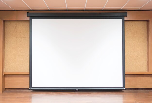 Widok z przodu sali wykładowej z pustym białym ekranie projektora