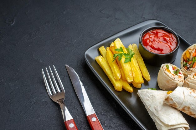 Widok z przodu smaczna kanapka pita shaurma w plasterkach z frytkami i keczupem na ciemnej powierzchni burger jedzenie fast food posiłek grill chleb przekąska tosty