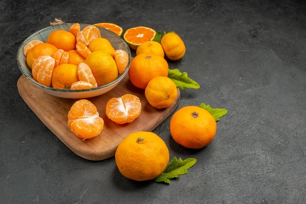 Widok z przodu smaczne soczyste mandarynki wewnątrz talerza na szarym tle kwaśny egzotyczny kolor cytrusowy zdjęcie pomarańczowe owoce