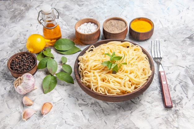 Widok z przodu smaczne spaghetti z przyprawami na białym stole z daniem z makaronu