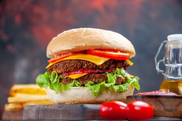 Widok z przodu smaczny burger mięsny z frytkami na ciemnym tle