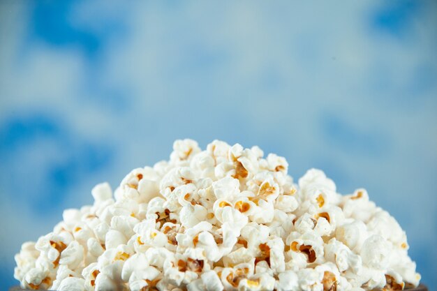 Widok z przodu smaczny świeży popcorn wewnątrz talerza na jasnoniebieskim tle