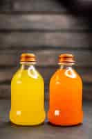 Bezpłatne zdjęcie widok z przodu sok pomarańczowy i żółty w butelkach